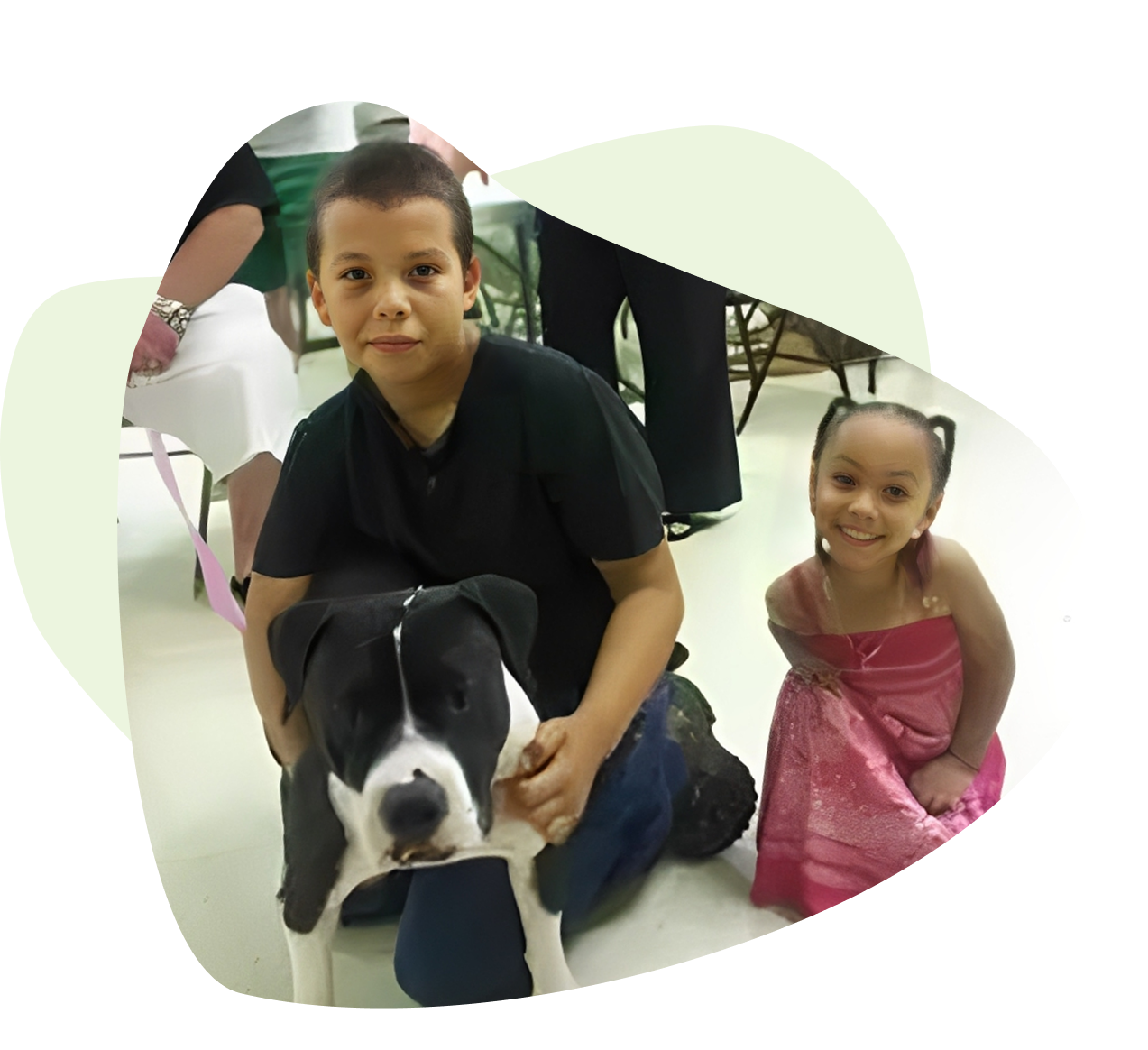 Group 1321317533 A boy and girl with their dog in the center of a room.